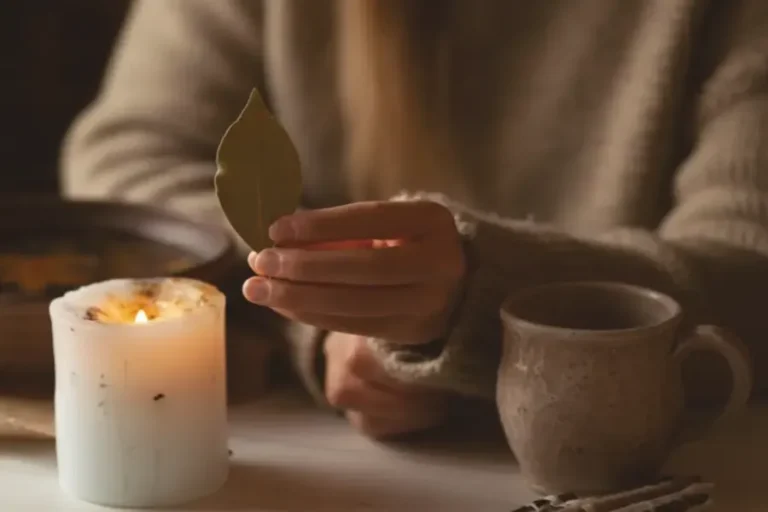 Ritualmoment mit brennender Kerze und Lorbeerblatt in ruhiger Atmosphäre auf hellem Tisch als Symbol für bewusste Rauhnächte und persönliche Spiritualität